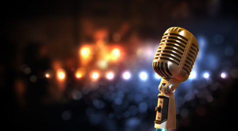 Single retro microphone against colourful background with lights